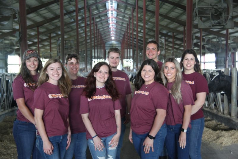 2021-2022 Dairy Science Ambassadors. Group shot taken in the dairy barn all wearing @VTDairyScience maroon shirts and jeans.